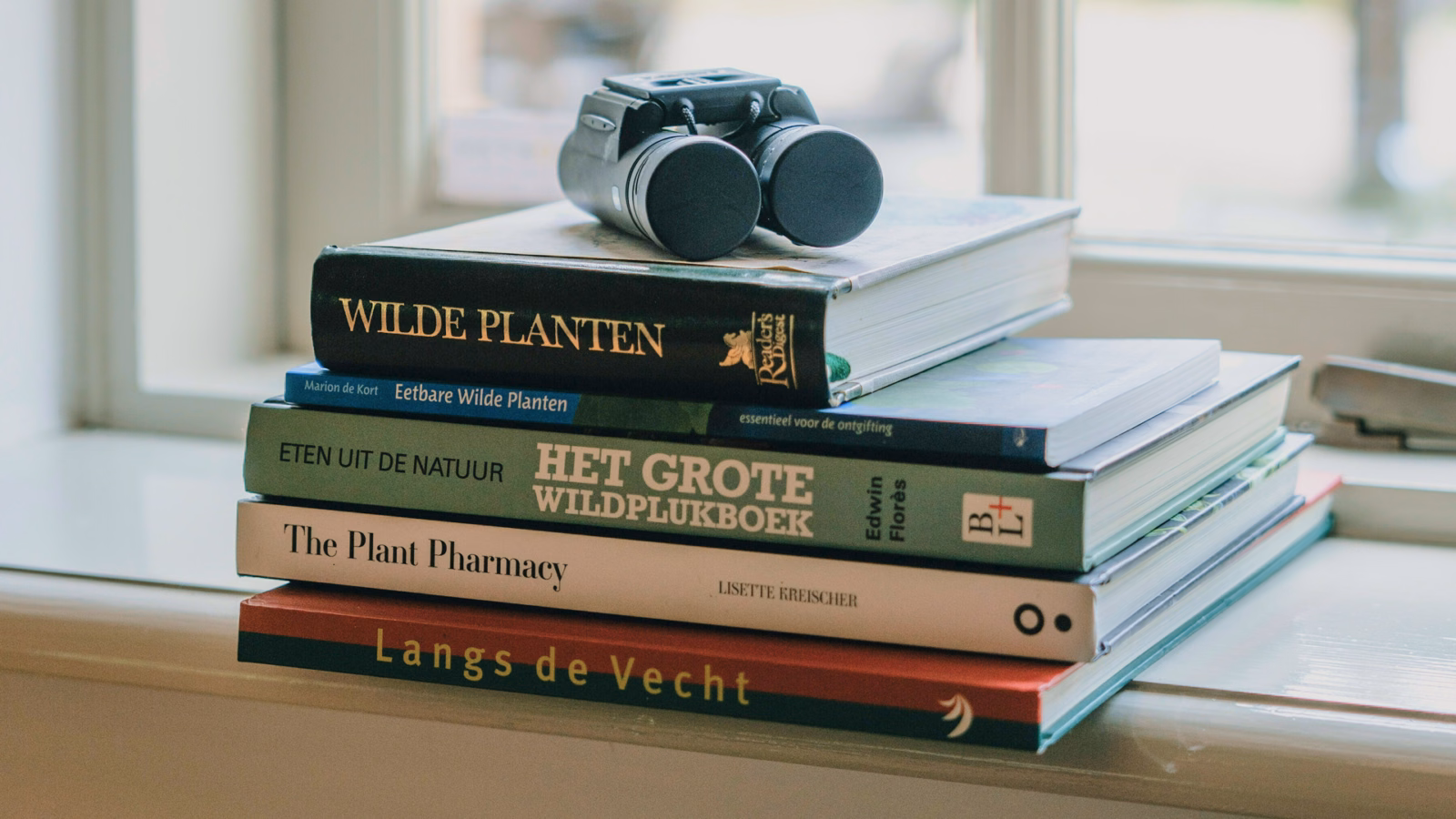 Stapel boeken met een verrekijker