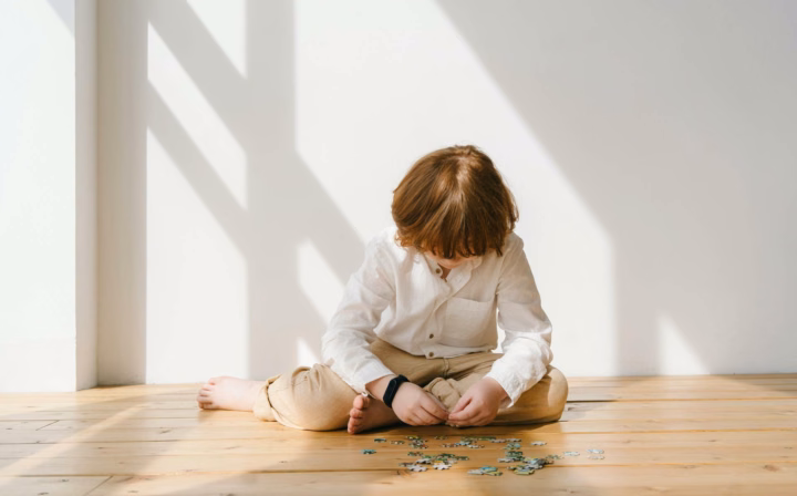 Foto van een kind die aan het puzzelen is