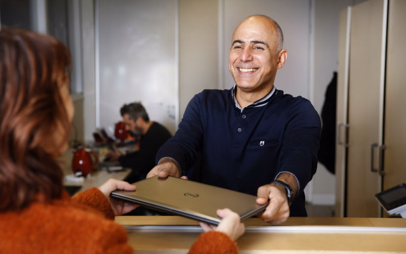 Man geeft laptop aan Cybersoek bezoeker