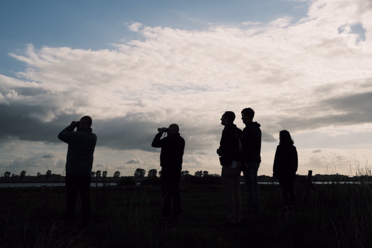 Group of Valsplat team members looking into the distance through binoculars.