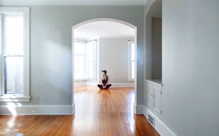 Woman sitting on the floor in an empty house.